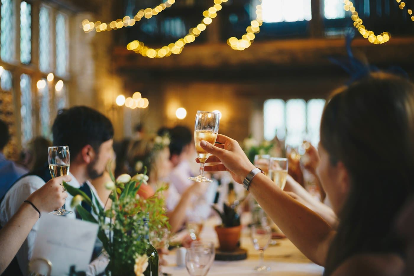 Guests raising champagne glasses at a candlelit reception